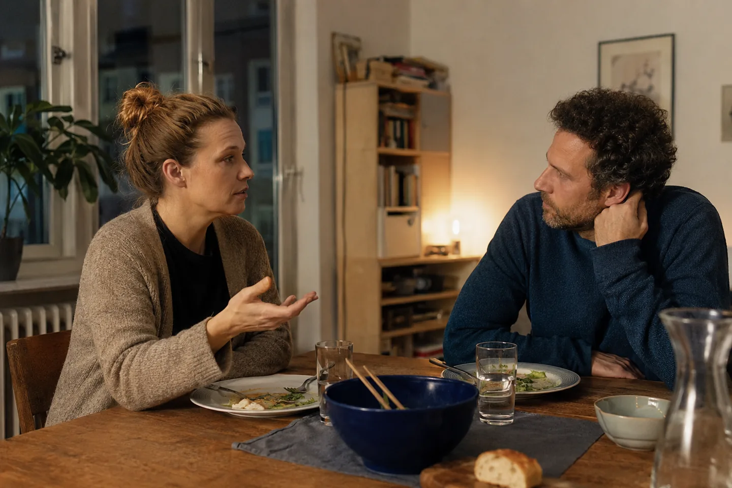 A couple talk attentively with each other after dinner.